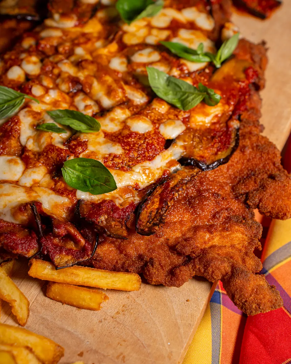 La maxi cotoletta di maiale alla pizzaiola con patatine